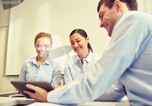 Image of smiling businesspeople with tablet pc in office