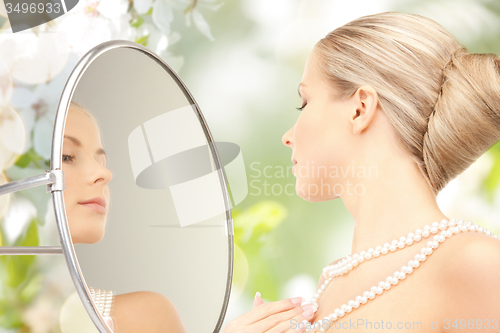 Image of beautiful woman with pearl necklace and mirror