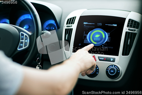 Image of male hand setting car eco system mode on screen