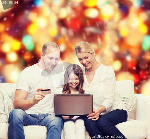 Image of happy family with laptop computer and credit card
