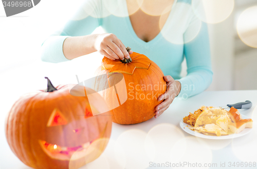 Image of close up of woman with pumpkins at home