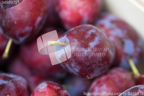 Image of close up of satsuma plums in box at street market