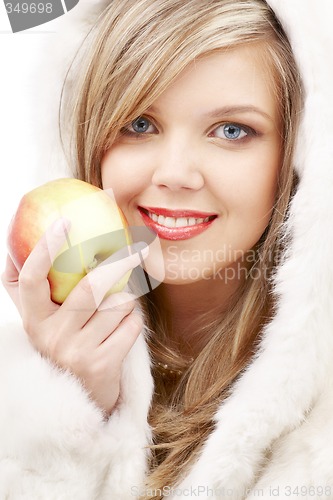 Image of lovely blond in fur with apple