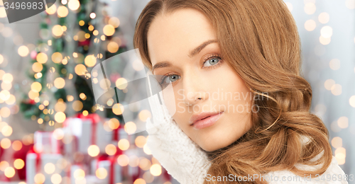 Image of happy woman in mittens over christmas lights