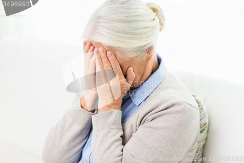 Image of senior woman suffering from headache or grief