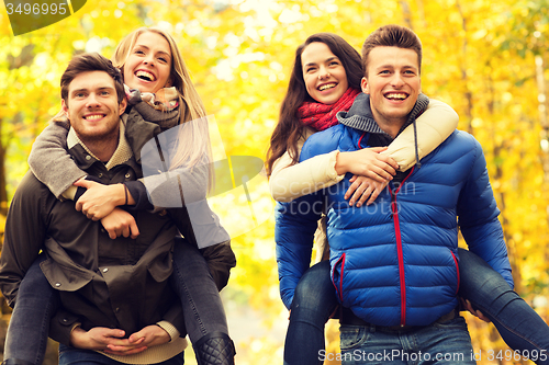 Image of smiling friends having fun in autumn park