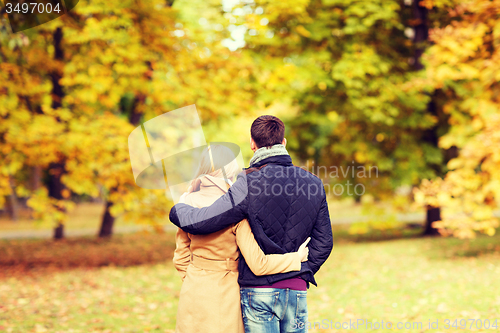 Image of couple hugging in autumn park from back