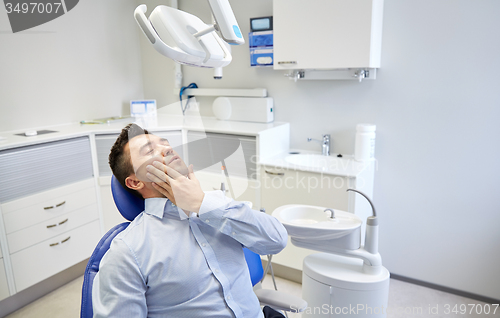 Image of man having toothache and sitting on dental chair