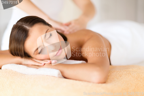 Image of beautiful woman in spa salon getting massage