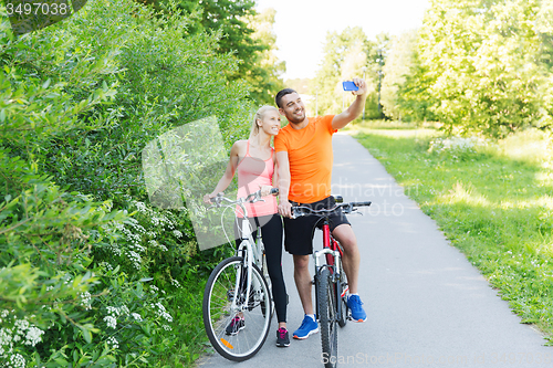 Image of couple with bicycle and smartphone taking selfie