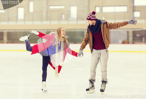 Image of happy couple holding hands on skating rink