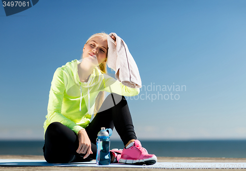 Image of woman resting after doing sports outdoors