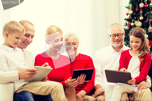Image of smiling family with tablet pc computers at home