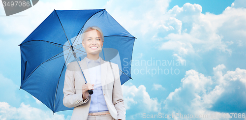 Image of young smiling businesswoman with umbrella outdoors