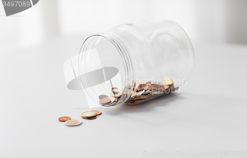 Image of close up of euro coins in big glass jar on table