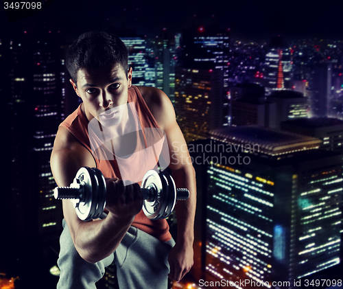 Image of young man with dumbbell flexing biceps