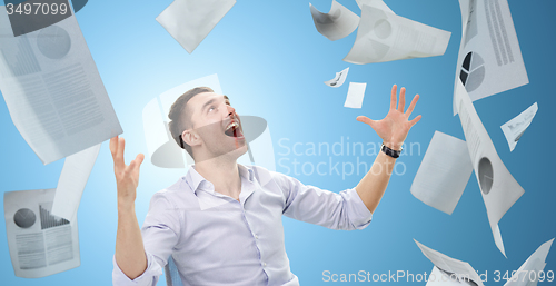 Image of businessman with falling papers
