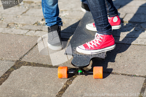 Image of close up of couple with longboard on street