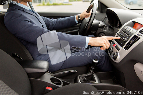 Image of close up of young man in suit driving car