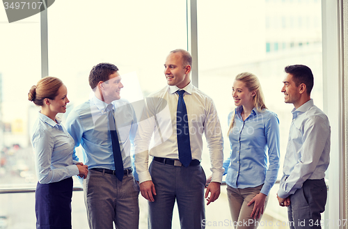 Image of smiling business people talking in office