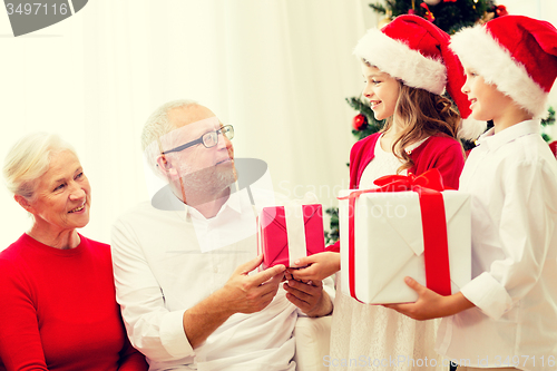 Image of smiling family with gifts at home