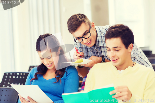 Image of group of smiling students with notebooks