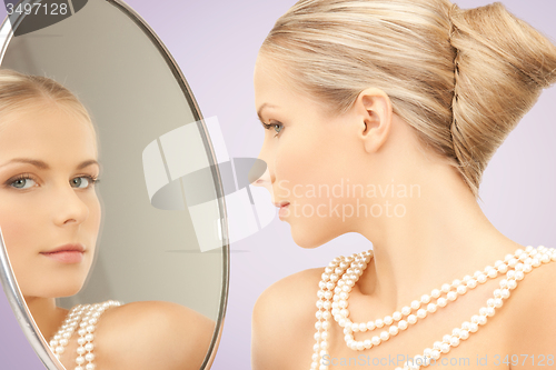 Image of beautiful woman with pearl necklace and mirror