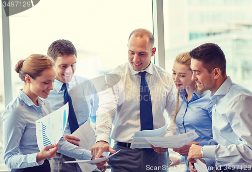 Image of business people with papers talking in office