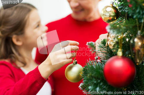 Image of close up of happy family decorating christmas tree