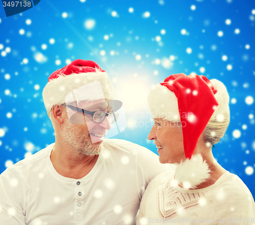 Image of happy senior couple in santa helper hats
