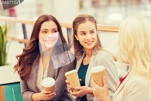 Image of young women with shopping bags and coffee in mall