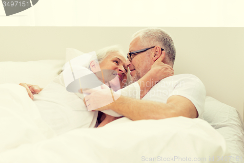 Image of happy senior coupler lying in bad at home