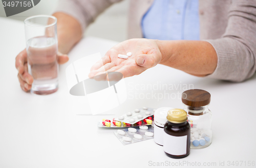 Image of close up of senior woman with pills and water 
