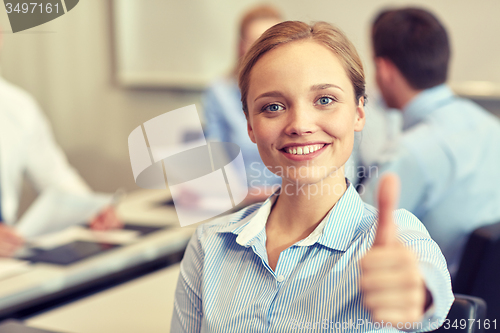 Image of group of smiling businesspeople meeting in office