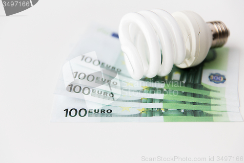 Image of close up of euro money and light bulb on table