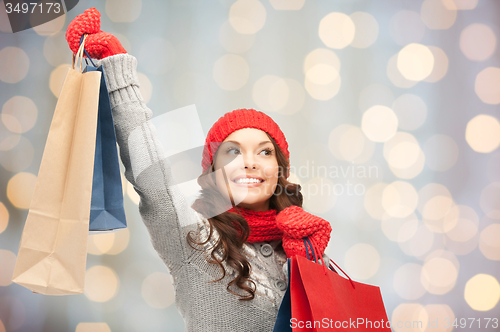 Image of happy woman in winter clothes with shopping bags