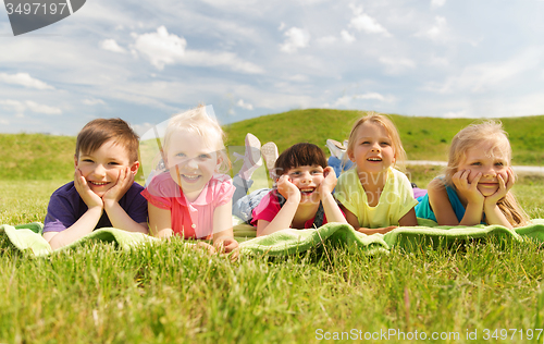 Image of group of kids lying on blanket or cover outdoors