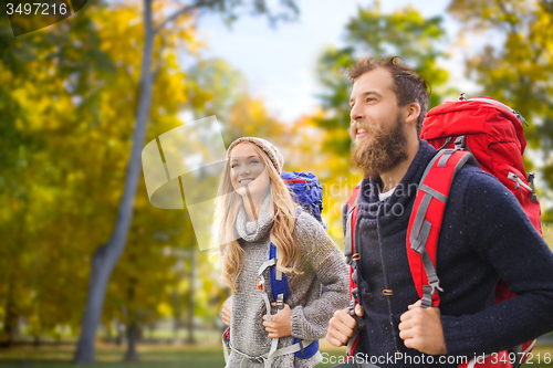 Image of smiling couple with backpacks hiking