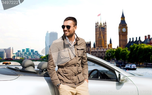 Image of happy man near cabriolet car over london city