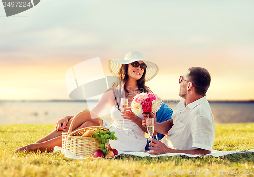 Image of smiling couple drinking champagne on picnic