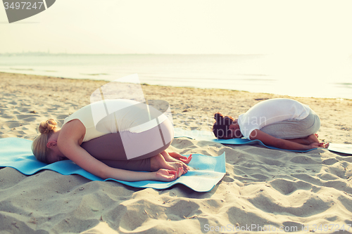 Image of couple making yoga exercises outdoors