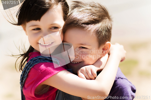 Image of two happy kids hugging outdoors