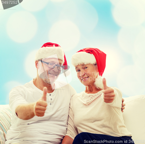 Image of happy senior couple in santa helper hats