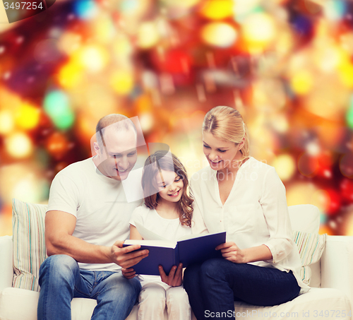 Image of happy family with book at home