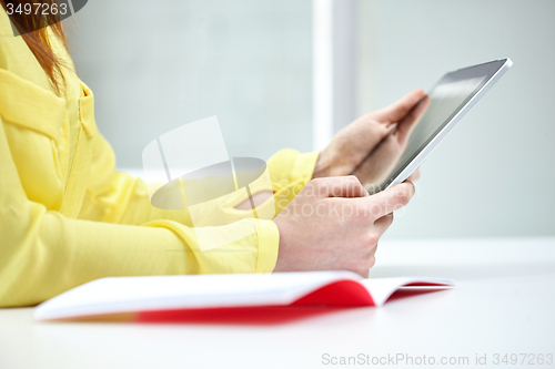 Image of close up of female hands with tablet pc at table