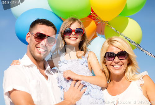 Image of happy family with colorful balloons outdoors