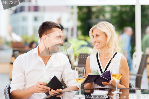 Image of happy couple with wallet paying bill at restaurant