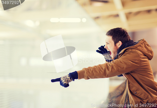 Image of young man supporting hockey game on skating rink