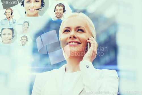 Image of smiling businesswoman with smartphone outdoors