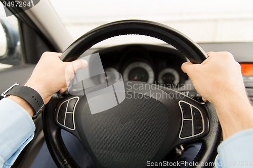 Image of close up of young man driving car